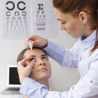 a female doctor inserting eye drops